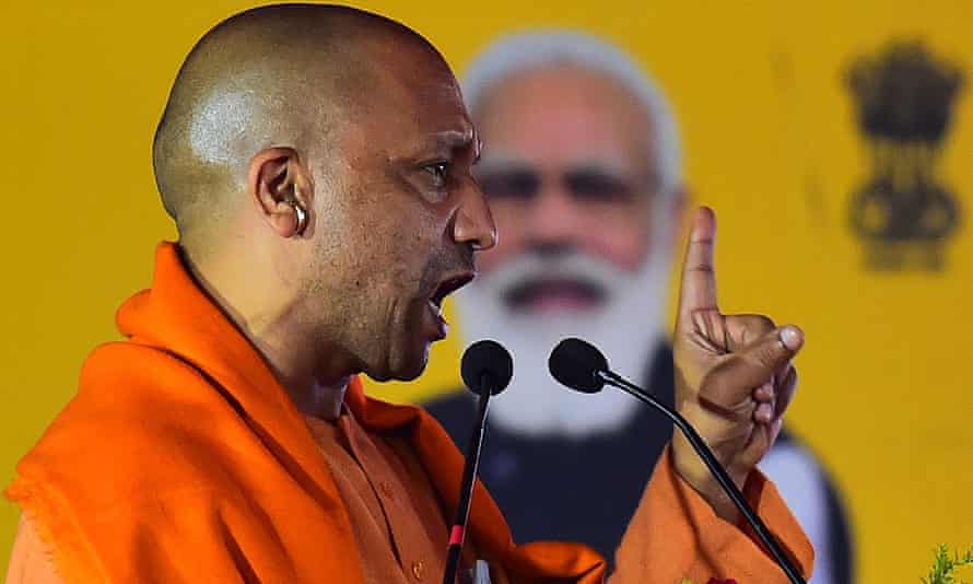 Chief minister of Uttar Pradesh Yogi Adityanath addresses a public rally, in front of an image of the prime minister, Narendra Modi