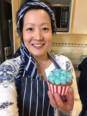Katrina Lau Hammond poses in her kitchen with a matte blue cupcake.