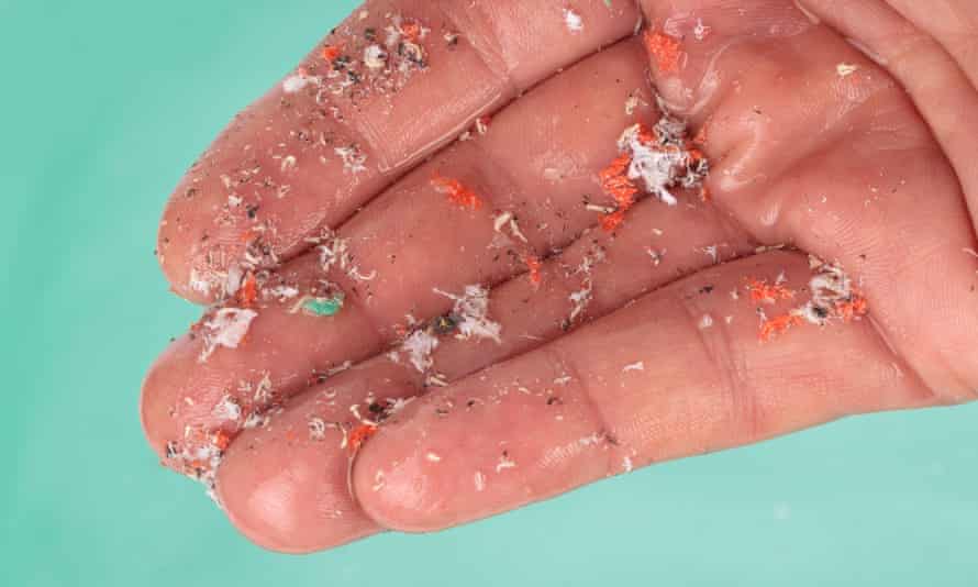 Hand details showing microplastics over water