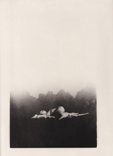 A woman lies stretched out among rocks on a volcanic island