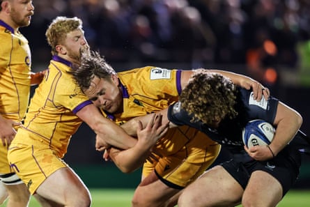 Bath's Alfie Barbeary is tackled by Northampton players.