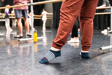 Close up of the socked feet of a person attending a ballet class.