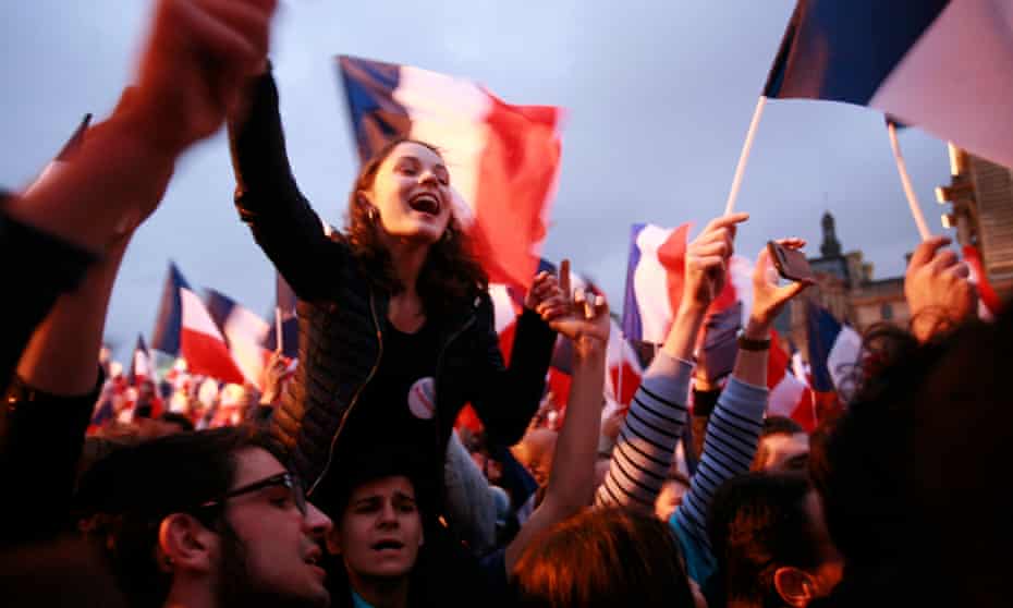 Supporters celebrate at a rally for Emmanuel Macron outside the Louvre on Sunday in Paris
