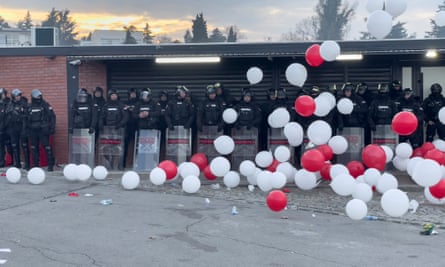 Police in riot gear stands ready as balloons that were part of pre-match choreography spill over the northern stand of the Marakana.