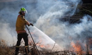 A firefighter puts out a blaze during a week-long wildfire on New Zealand’s South Island. A firefighter puts out a blaze during a week-long wildfire on New Zealand’s South Island.