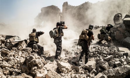 Iraqi soldiers shooting at IS fighters hiding behind a berm in the Old City of Mosul.