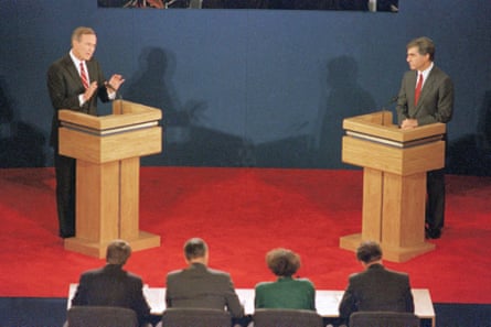 two men in suits at wooden lecterns