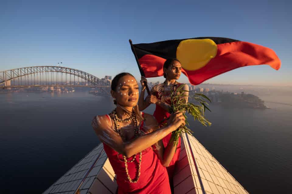 Dharpaloco (Dubs) Yunupingu and Abigail Delaney from Jannawi Dance Clan fly the Aboriginal flag atop the Sydney Opera House in 2019
