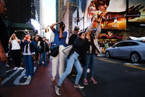 Crowds take photographs of the sunset at 42nd Street in Times Square