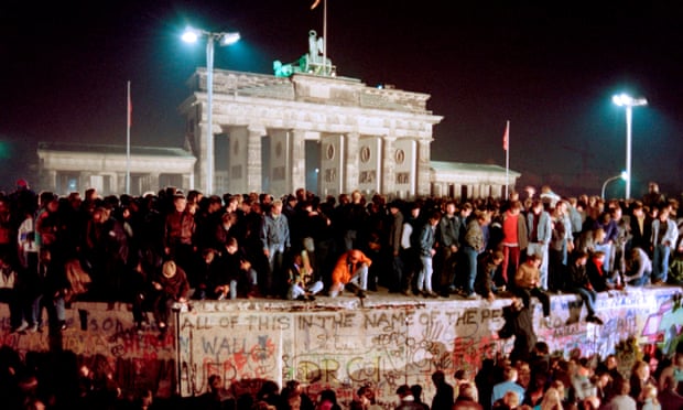 Thousands of East Berliners crowd atop the Berlin Wall, near the Brandenburg Gate
