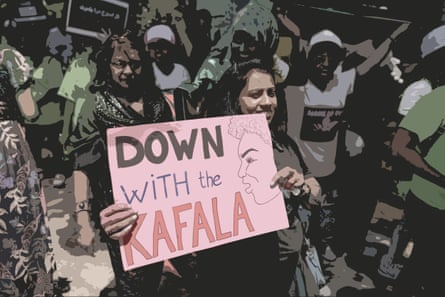 A woman surrounded my other protesters holds a sign saying ‘down with the kafala’. 
