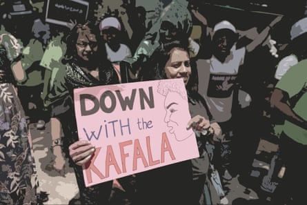 A woman surrounded my other protesters holds a sign saying ‘down with the kafala’.