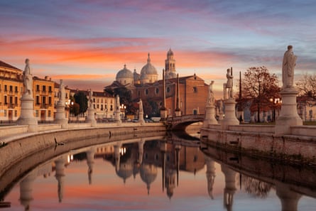 Beautiful Italian city and statues on a lake at dusk