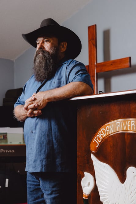 a man in a cowboy hat stands beside a pulpit