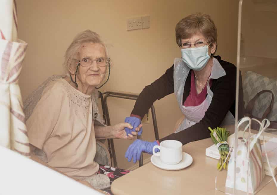 Christine Percival and her mother, Rachel, in the residence's visiting room, shot through the window.