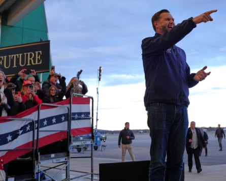 A man points and stands in front of a group of people.
