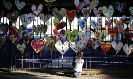 DOUNIAMAG-BRITAIN-FIRE-CARNIVAL-LIFESTYLEA young girl adds finishing touches to paper hearts adorning a fence in Kensington, near the burnt-out remains of Grenfell Tower in London on August 25, 2017 ahead of the Notting Hill Carnival. The art work is being made by volunteers from the community devestated by the Grenfell tower fire disaster as part of a project called Green for Grenfell in which paper hearts, banners, posters and bunting relating to the Grenfell tower tragedy are being made out of recycled materials to adorn the streets in time for the Notting Hill Carnival this coming weekend. / AFP PHOTO / Tolga AKMEN (Photo credit should read TOLGA AKMEN/AFP/Getty Images)