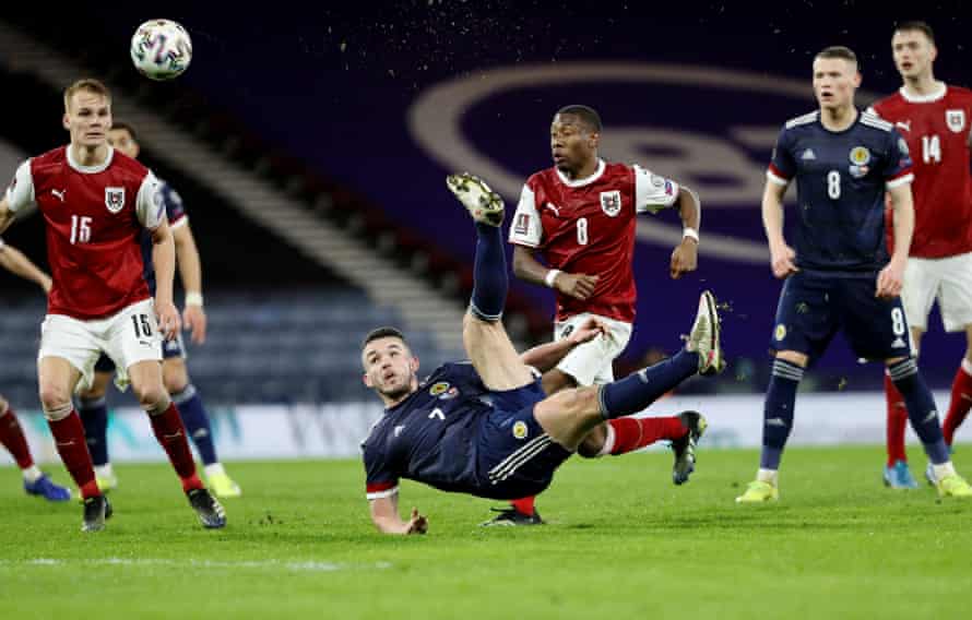 Scotland’s John McGinn scores with a scissor kick.