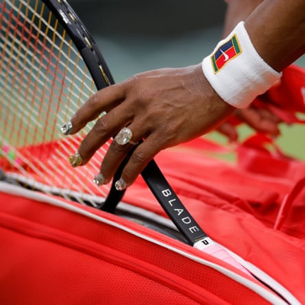 Serena Williams, with diamond ring and diamond encrusted nails, gets her racket out of her bag to start her first round match with Maya Joint