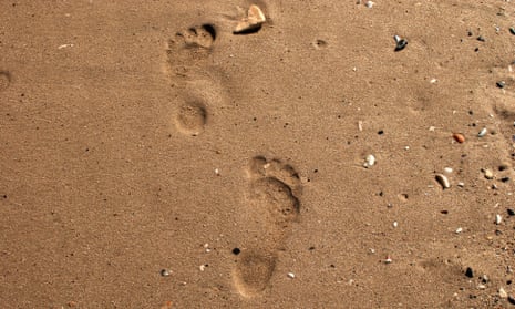 Bare human stepsSteps of bare human feet on wet sand of sea beach