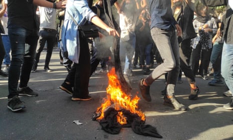 Iranian protesters set their scarves on fire in Tehran, 1 October.