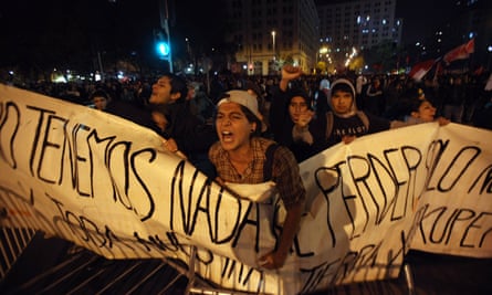 Ambientalistas gritam slogans em frente a policiais durante uma manifestação organizada em Santiago, em 2001, para protestar contra a construção de uma hidrelétrica no sul da Patagônia chilena.