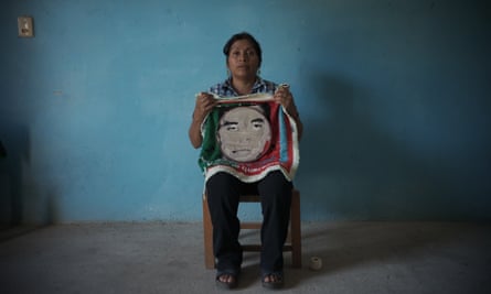 Cristina Bautista sits for a portrait holding a half knitted sign picturing her son Benjamín Ascencio Bautista,