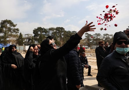 A mourner throws flowers during a funeral ceremony for victims of Israeli and US strikes in Tehran
