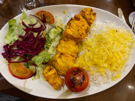 A kebab, salad and rice on a plate.