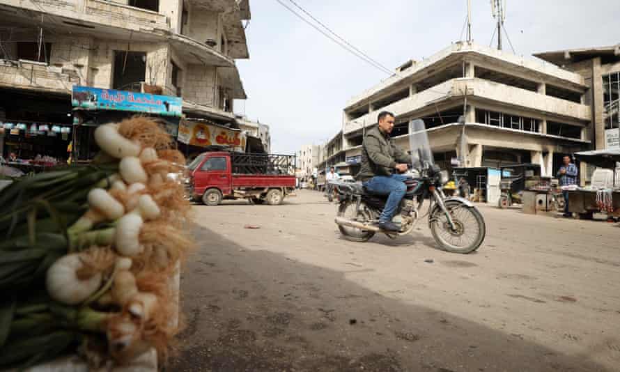 A man rides a motorcycle in the north-western Syrian city of Idlib on the first day of a Turkey-Russia ceasefire.
