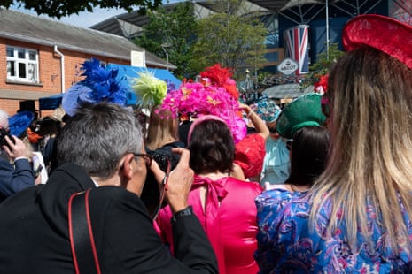 A photographer takes snaps of elegant racegoers waiting to go into Ascot racecourse.