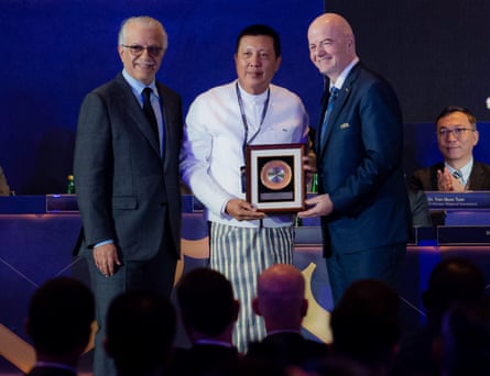 Zaw Zaw poses for a picture holding his award, flanked by Infantino (right) and Khalifa