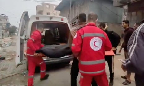 Members of the Palestine Red Crescent Society carry a casualty on a stretcher to an ambulance in Khan Younis, Gaza