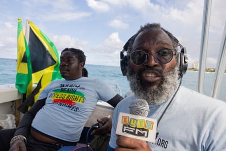 Dr Devon Taylor broadcasts into a microphone from a boat during a beach access protest