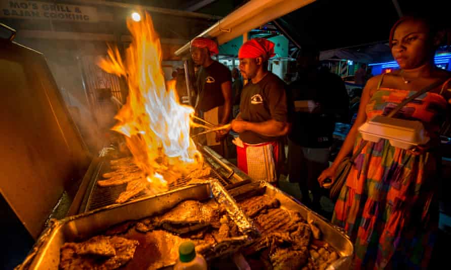Cooks frying up fish on a BBQ at Oistins fish fry night, Barbados
