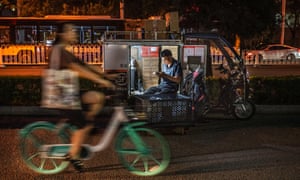 A courier sits in his vehicle as he prepares deliveries in Beijing this month.