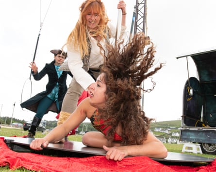 circus performance with a woman lying on the ground and another woman standing over her