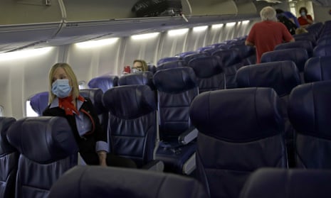 A Southwest Airlines flight attendant waits at left, as the final passengers board a plane.