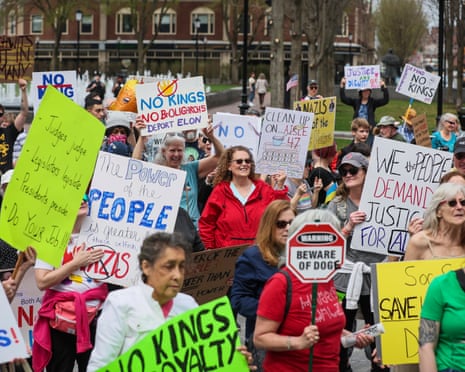 Demonstrators hold various signs including "The Power of the People" and "No Kings No Royalty" at a pro-democracy rally in Hancock Adams Common on April 19, 2025.