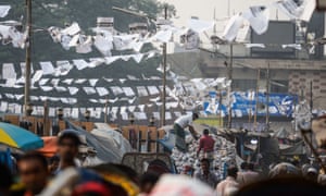 Bangladeshi workers work under posters of election candidates who have been shut out by mainstream media and are too scared to campaign on the streets.