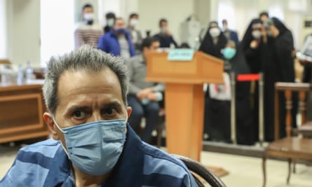 Jamshid Sharmahd in court wearing face mask with people in background