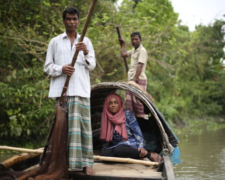 Nadiya Hussain sitting in a boat with two men using poles at the front and back, travelling along a waterway.