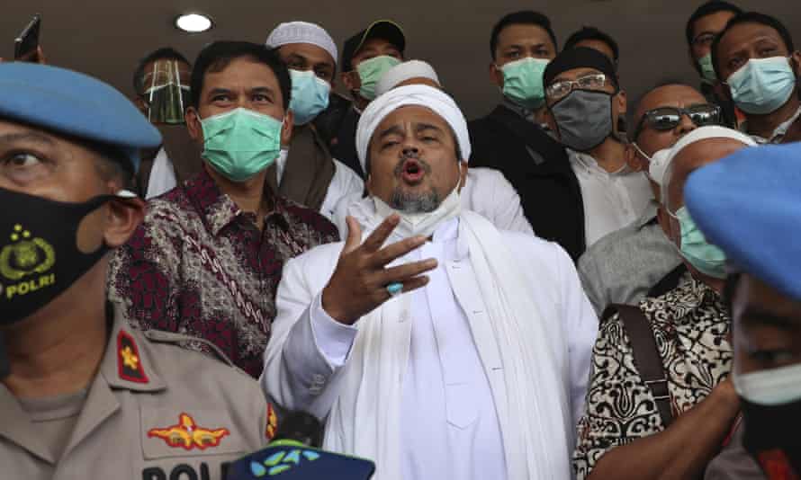 Rizieq Shihab, centre, talks to reporters at police headquarters in Jakarta