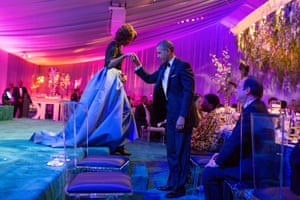The president helps the first lady off the stage during a state dinner for French president François Hollande