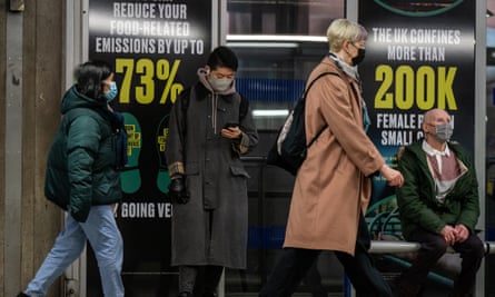 Des personnes portant des masques dans une station de métro de Londres.