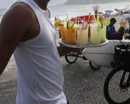 A vendor carries caipirinhas to beachgoers at Ipanema Beach
