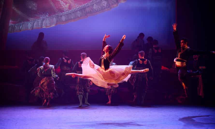 A ballet dancer snapped centre stage in midair, wearing a long flowing skirt