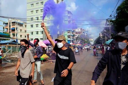 A young demonstrator lights a flare during an anti-coup protest in Yangon, Myanmar in 2022.