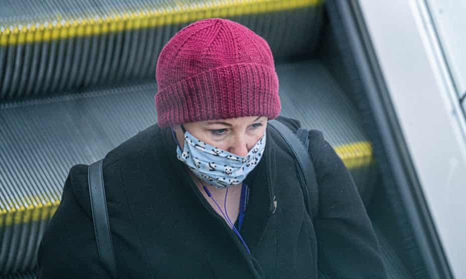 Masked commuter on escalator