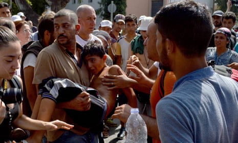 Refugees carry a boy in Mytilene, the capital of Lesbos